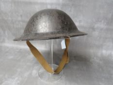 A 1939 DATED BLACK PAINTED BRITISH TIN HELMET (Rubry Owen)