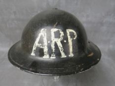 A 1938 DATED ARP HELMET, black painted with white letters