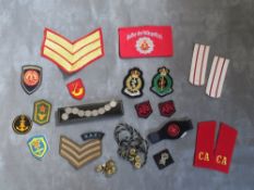 A BOX OF ASSORTED CLOTH AND OTHER BADGES, to include Communist types, along with a GDR armband, a