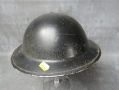 A 1943 DATED BLACK PAINTED BRITISH TIN HELMET