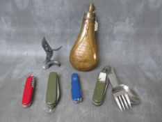 AN ANTIQUE COPPER POWDER FLASK, with embossed decoration and a quantity of pen / pocket knives