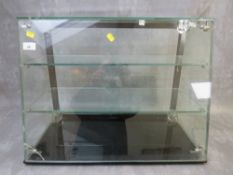 A PLATE GLASS TWO SHELF SHOP DISPLAY CABINET WITH SLOPING FRONT, sliding doors to back, H 46 cm, W