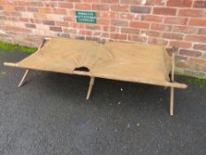 A MILITARY FOLDING CAMP BED, of wood and canvas construction