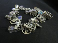 A CHARM BRACELET WITH 38 CHARMS, some of which are hallmarked