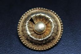 A YELLOW METAL MOURNING BROOCH IN THE FORM OF A DAISY, one petal missing, in unmarked yellow