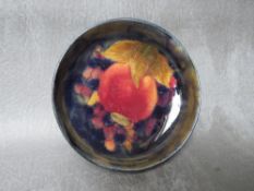 A MOORCROFT POMEGRANATE SHALLOW CIRCULAR DISH, with ribbed rim, impressed marks to the base, Dia. 12