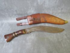 AN EARLY MILITARY KUKRI KNIFE, in leather covered wooden sheath, bearing date 1917 and inscription
