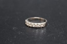 AN 18CT WHITE GOLD SEVEN STONE DIAMOND RING, each diamond being of an estimated 10 pts, approx