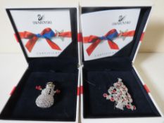 TWO BOXED SWAROVSKI CHRISTMAS THEMED BROOCHES, comprising a Christmas tree - H 5.5 cm and a snowman,