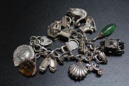 A SUBSTANTIAL SILVER CHARM BRACELET ADORNED WITH MANY LARGE CHARMS, approx weight 138g
