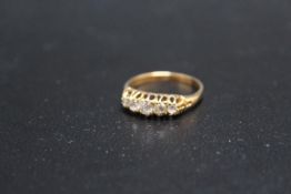 A GRADUATING DIAMOND FIVE STONE RING, set in yellow metal stamped 18, approx weight 3.9g, ring