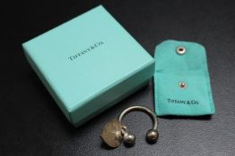 A TIFFANY & CO SILVER KEY RING HOLDER WITH HEART SHAPED TAG, complete with a box and a bag, approx