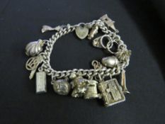 A CHARM BRACELET WITH HALLMARKED SILVER PADLOCK, with 15 attached charms, some hallmarked