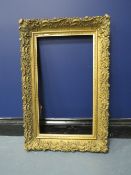 A 19TH CENTURY DECORATIVE GOLD FRAME, frame W 7 cm, rebate 54 x 30 cm