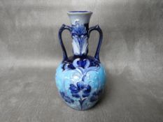 A MOORCROFT FOR MACINTYRE & Co FLORIANWARE TWIN-HANDLED VASE, circa 1900, with impressed and printed