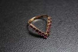A HALLMARKED 9 CARAT GOLD V SHAPED RING, set with ruby type stones, approx weight 2.3g