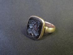 A GEORGIAN GOLD INTAGLIO CORNELIAN RING, of shaped rectangular form, unmarked and untested,