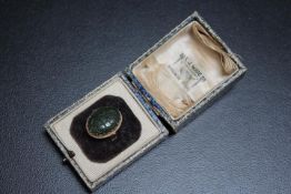 A HALLMARKED 9 CARAT GOLD CARVED OVAL JADE RING, carved with floral design, approx weight 5.4g, ring