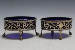 A PAIR OF GEORGIAN HALLMARKED PIERECED SILVER SALT DISHES - LONDON 1773, with blue glass liners,