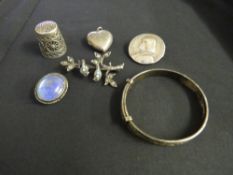 A SMALL TRAY CONTAINING A FILIGREE THIMBLE, silver heart locket, a silver child's bangle,