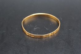 A YELLOW METAL BABY'S BANGLE, stamped PJ21, approx weight 6.8g, Dia 5 cm