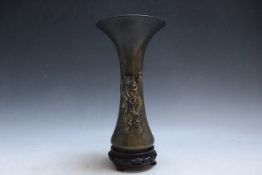 AN ORIENTAL BRONZE FLARED VASE, decorated with a figure blowing bubbles, character marks to the