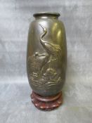AN ORIENTAL DECORATIVE BRONZE VASE, decorated with two cranes in relief, together with a stand, vase