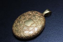 A HALLMARKED 18 CARAT GOLD LOCKET, with chased engraved decoration throughout, vacant cartouche