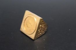 A HALLMARKED 9 CARAT GOLD RING SET WITH A QUEEN VICTORIA SOVEREIGN, in a 'squared' setting, approx