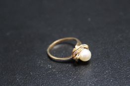 A PEARL RING, set in yellow metal stamped k15 on a 'swirl' bed with blue enamelling, A/F approx