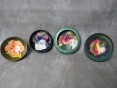 A MOORCROFT 'ORCHID' PATTERN CIRCULAR DISH, Dia. 11 cm, together with three further Moorcroft