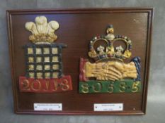 TWO PAINTED LEAD FIREMARKS SET ON A WOODEN PLAQUE, 'Westminster Fire Office 1717-1906' and 'Hand