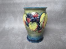 A MOORCROFT LEAF AND BERRY PATTERN BALUSTER VASE, impressed marks and sticker to the base, H 13 cm