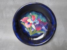 A WILLIAM MOORCROFT ORCHID PATTERN CIRCULAR SHALLOW DISH, impressed and signed marks, Dia. 18 cm