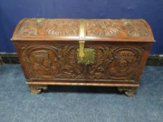 A DOMED 18TH CENTURY CARVED OAK COFFER WITH ORIGIANL KEY, the domed carved top with armorial detail,
