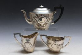 A CHINESE EXPORT SILVER THREE PIECE TEA SERVICE, boldly embossed with a three toed dragon, character