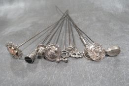 A COLLECTION OF SILVER AND WHITE METAL HATPINS, to include a hallmarked silver golf club example,