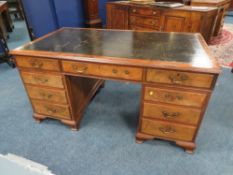 A 20TH CENTURY WALNUT TWIN PEDESTAL DESK, with inset tooled leather writing surface, having an
