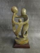 A MODERN BRITISH SCHOOL ABSTRACT SCULPTURE, depicting three figures on a wooden base, H 30 cm