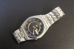A SEIKO AUTOMATIC BLACK FACE WATCH, with day & date, Dia. 3 cm