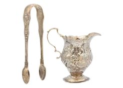 A George III silver cream jug and a Victorian silver pair of sugar tongs.