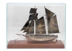 A good modern hallmarked silver model of a Topsail Schooner in a glass display case.