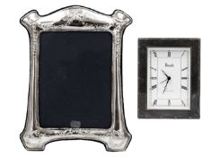 A modern silver photo frame and a silver framed timepiece by Harrods.