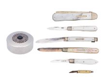 A silver pill box, five mother-of-pearl pocket knives and a miniature celluloid pocket knife.