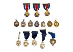 A collection of twelve hallmarked silver medallions with ribbons.