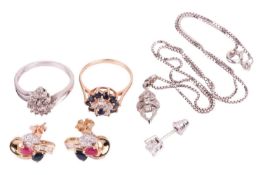 A collection of two rings, a pair of earrings with a single stud earring and a pendant. Featuring a 