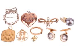 A small collection of jewellery items including a ruby and diamond set heart locket, in a yellow met