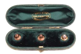 Three shirt studs in a fitted Hall & Co Manchester box, in yellow metal one stamped 15ct. Total 