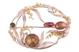 A tourmaline brooch by Polly Gasston, in a floral and foliate design in bi-colour gold set with cabo
