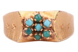 A seven-stone turquoise cluster ring; the small circular cut beads set between wide, textured and en